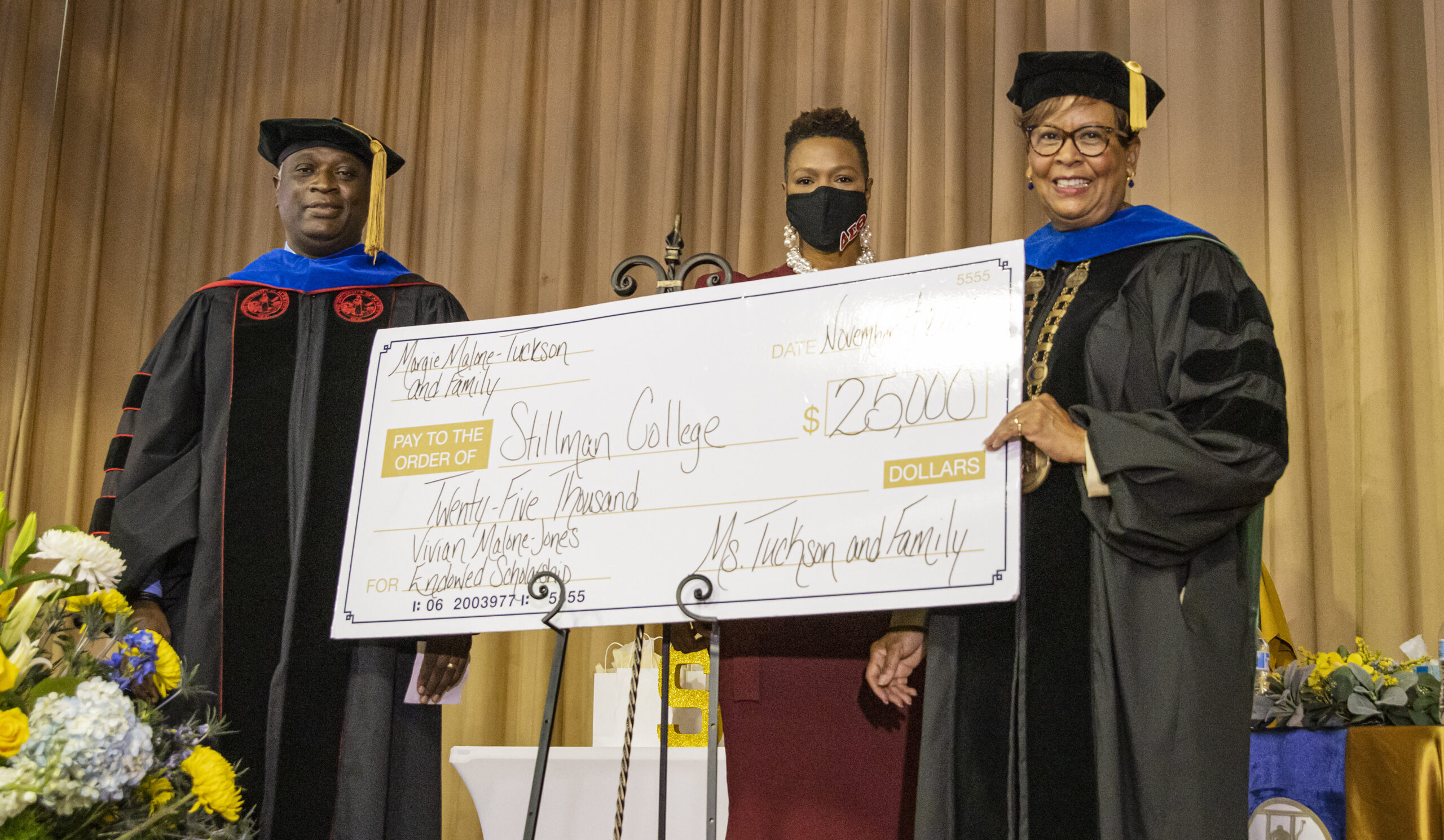 A group of Black college administrators accept a check for a scholarship fund