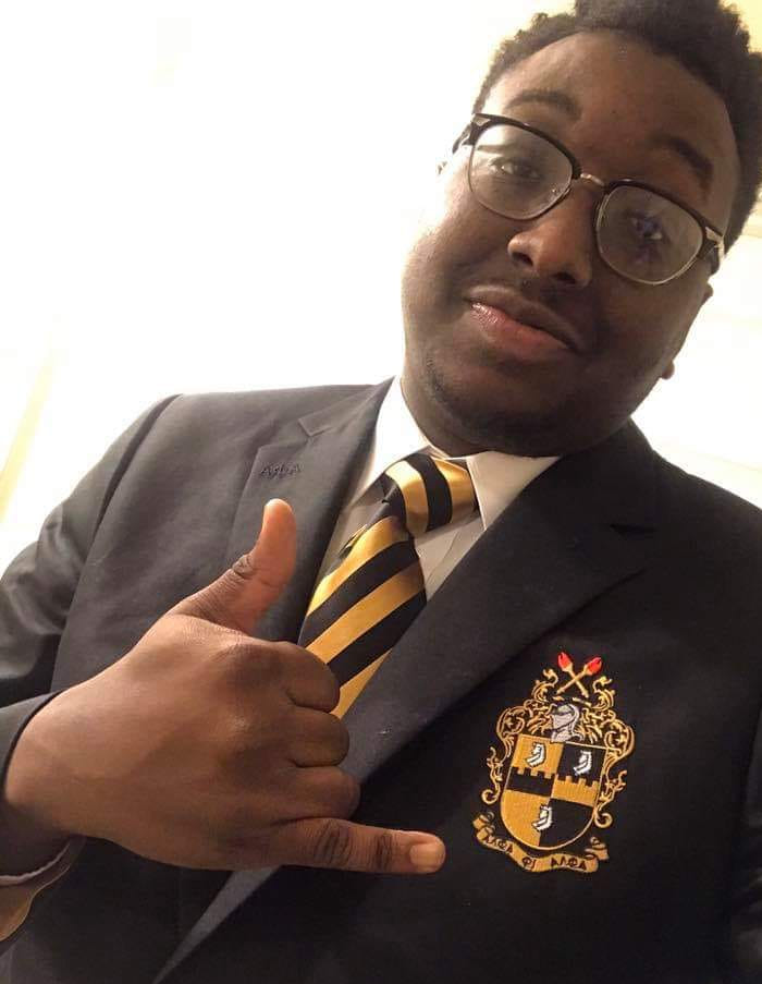 a black male college student poses for a selfie