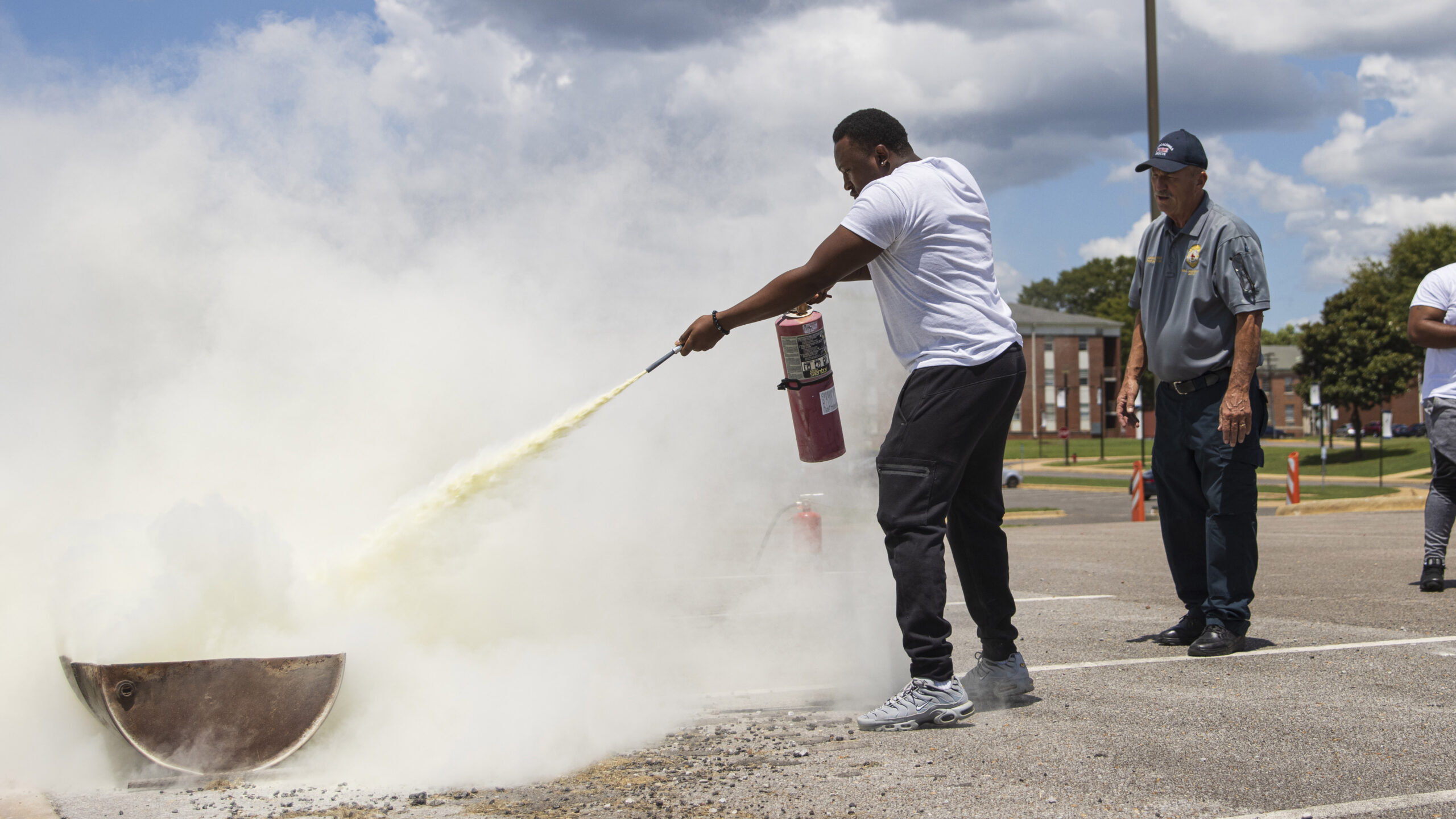 A black college student extinguishes a small fire during a training session