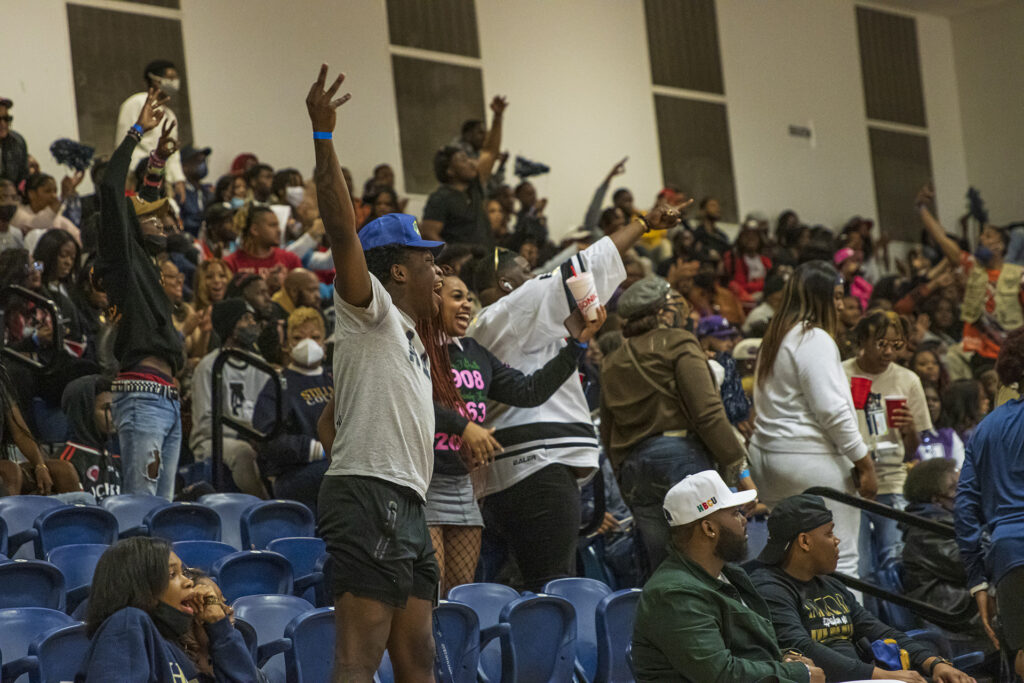 A crowd of black people celebrate a goal at a basketball game