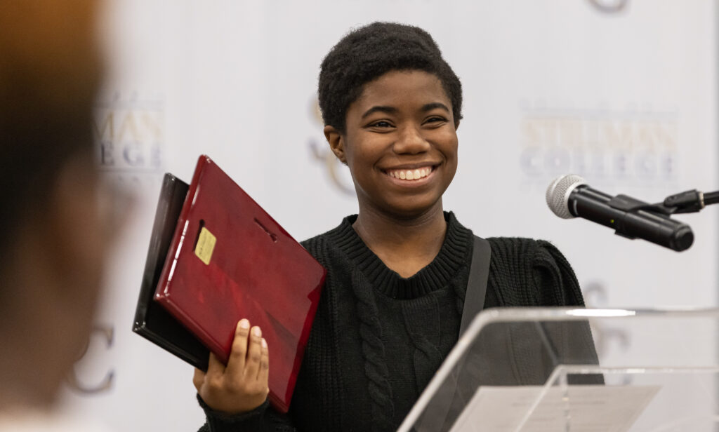 A black female college student speaks at a lectern